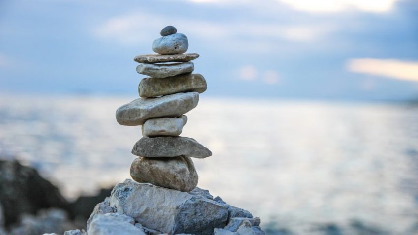 Peaceful stone stack by a serene ocean, symbolizing balance and tranquility.